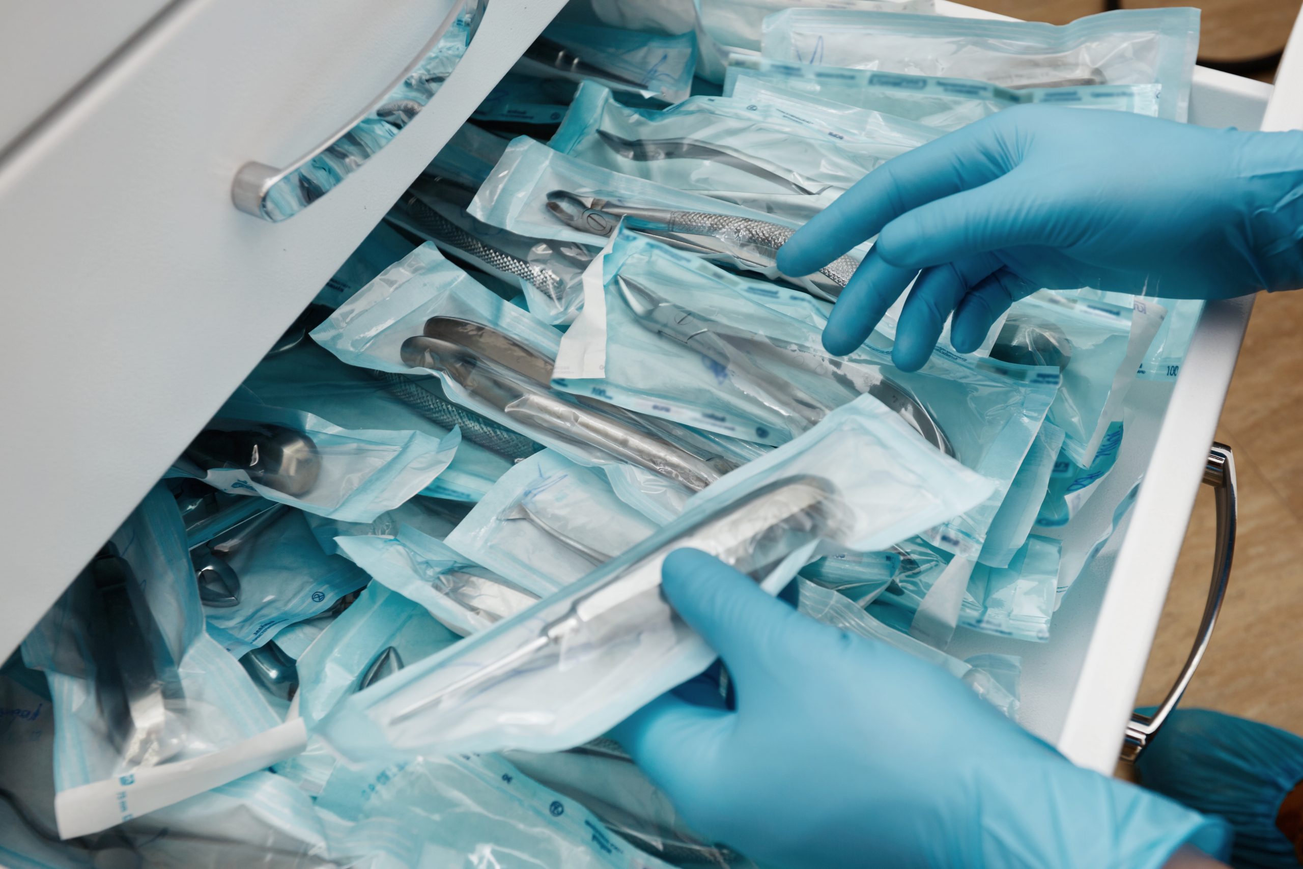 medical laboratory technician holding set sterile disposable instruments scaled